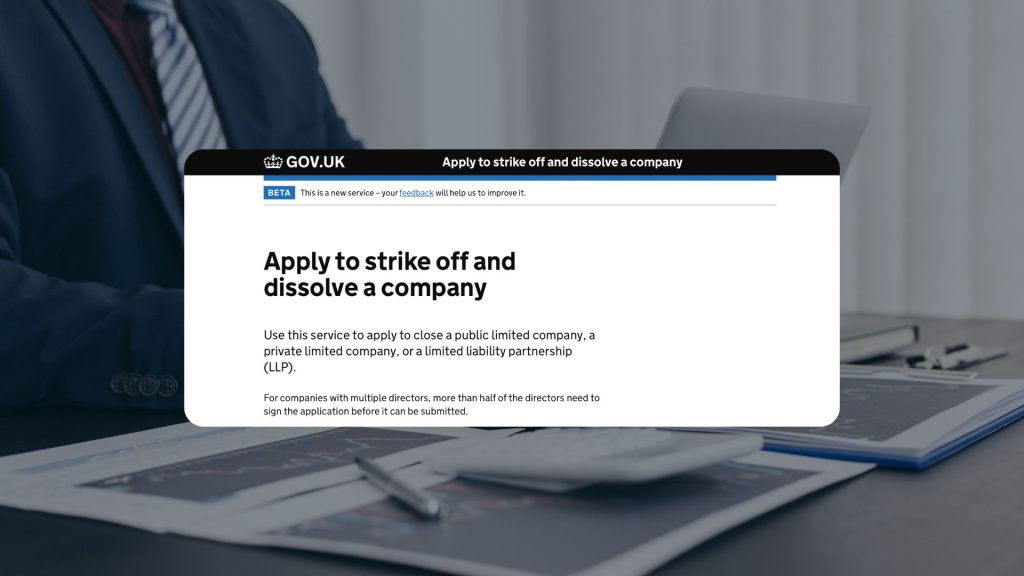 Screenshot of the GOV.UK 'Apply to strike off and dissolve a company' online service, overlaid on a blurred image of a businessperson at a desk with financial documents and a calculator.