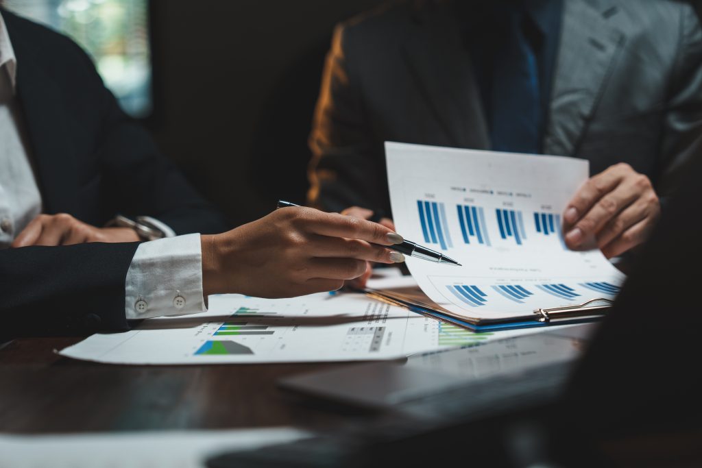 Business professionals reviewing financial reports and charts planning for company liquidation