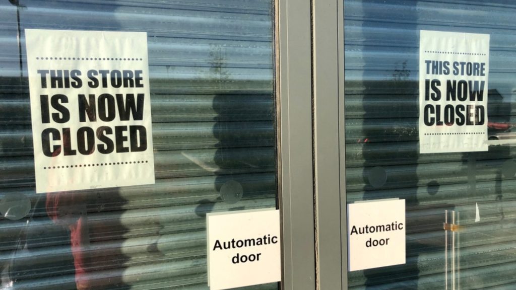 front of uk glass shop doors showing 'this shop is now closed' signs